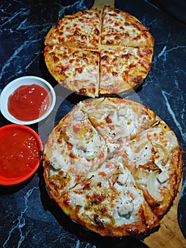 Margaritha and chicken pizza with tomato and chili sauce