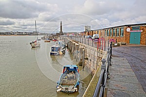 Margate Harbor Arm with mooring boats and the lighthouse in the background, Margate, Kent, UK