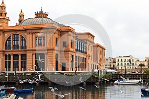 Margherita Theater and fishing boats in old harbor of Bari, Puglia, Italy