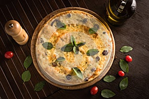 marguerita pizza with top view, decorated with basil, cherry tomatoes and black olives.