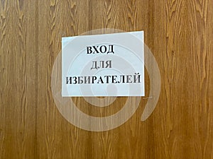 Mari El, Russia - September 16, 2021: On a wooden door or wall there is a sheet of white paper with an inscription in