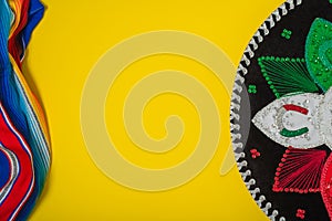 Mariachi hat and serape on yellow background.