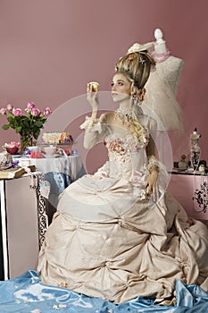 Marie Antoinette in pink holding a cupcake
