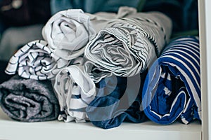 Marie Kondo tyding up method concept - folded clothes. White, gray, blue and striped T-shirts