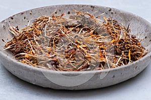 Marigold Dry Seeds Mexican marigold, Aztec marigold, African marigold in ceramic plate on gray. Tagetes erecta. Dais