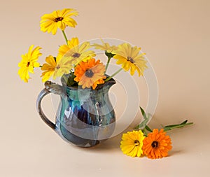 Marigold flowers in vintage vase. Bouquet yellow and orange flowers on pastel background