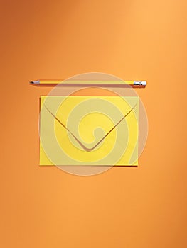 Marigold orange coloured envelope and pencil