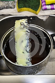 Marijuana green butter made in metallic cooking pot in kitchen