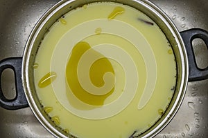 Marijuana green butter made in metallic cooking pot in kitchen