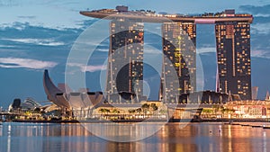 Marina Bay Sands Hotel dominates the skyline at Marina Bay in Singapore night to day timelapse.