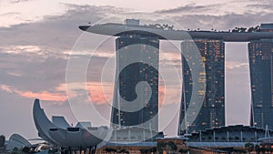 Marina Bay Sands Hotel dominates the skyline at Marina Bay in Singapore night to day timelapse.