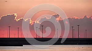 Marina entrance at dawn with orange sky with clouds and seagulls