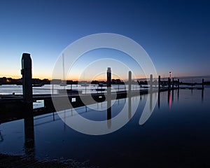 A marina jetty just before dawn with calm waters