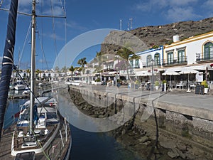 Marina, ships and colorful buildings of Puerto de Mogan. Traditional spanish colonial architecture of small fishing