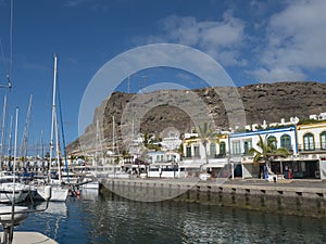 Marina, ships and colorful buildings of Puerto de Mogan. Traditional spanish colonial architecture of small fishing