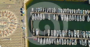 Marina with yachts and the square with Compass Rose in front of the Monument of the Discoveries. Made of black and red