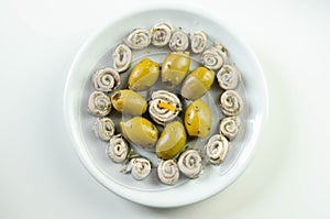 Marinated anchovies with lemon vinegar olive oil parsley and green olives photo