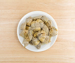 Marinated artichoke hearts on a plate atop a table