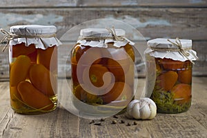 Canned tomatoes in jar on the wooden table