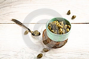 Marinated capers in a ceramic bowl. Edible flower buds of Capparis spinosa, caper bush or Flinders rose on a light background