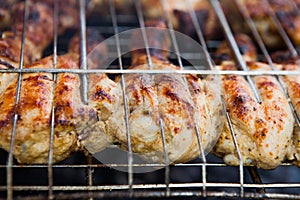 Marinated chicken legs on the grill in the smoke. A picnic, tasty food. BBQ