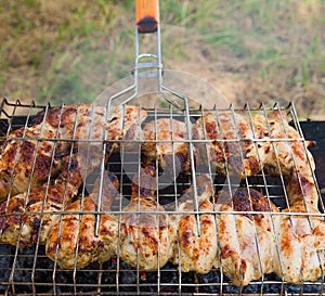 Marinated chicken legs on the grill in the smoke. A picnic, tasty food. BBQ