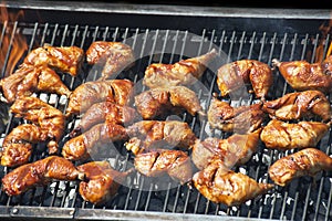 Marinated Chicken legs grilling on a summer barbecue