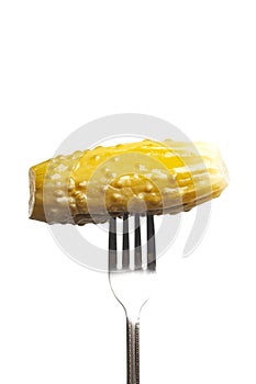 Marinated cornichon on the fork isolated on the white background