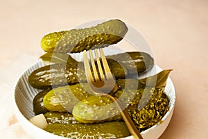 Marinated cucumbers in a bowl on a light background.