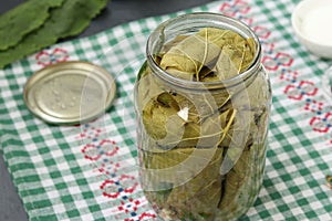 Marinated cucumbers in grape leaves in jar for the winter with garlic and dill, preparatory process