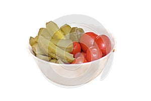 Marinated cucumbers and red tomatoes in a white plate, close-up