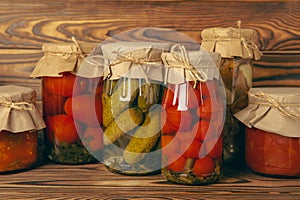 Marinated food.Assortment of homemade jars with a variety of marinated and pickled vegetables on a wooden table.