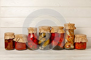 Marinated food.Assortment of homemade jars with a variety of marinated and pickled vegetables on a wooden table.