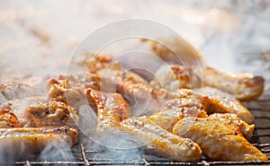 Marinated, fried with a crispy golden crust fried chicken wings on the grill.