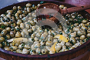 Marinated green pitted olives in a wooden casket