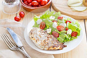 Marinated Grilled Healthy Chicken Breast served with Fresh Salad on a Wooden Background