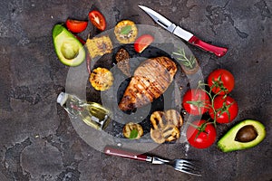 Marinated grilled healthy chicken breasts cooked on BBQ and served with fresh tomato, avocado, potatoes and corn