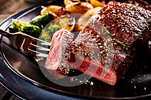 Marinated medium rare round steak slice on fork