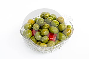 Marinated olives in small transparent bowl. On white background