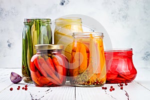 Marinated pickles variety preserving jars. Homemade green beans, squash, radish, carrots, red chili peppers pickles.