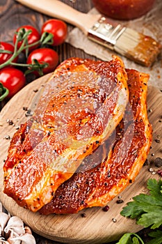 Marinated pork steaks on cutting board