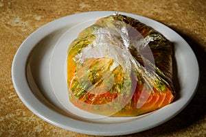 Marinated raw salmon fillet lie on white plate