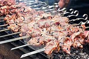 Marinated shashlik preparing on a barbecue grill over charcoal. Roasted stacked meat Shish kebab popular Eastern Europe. Shashlyk