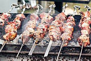 Marinated shashlik preparing on a barbecue grill over charcoal. Roasted stacked meat Shish kebab popular Eastern Europe. Shashlyk