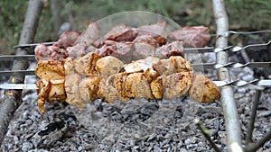 Marinated shashlik or shish kebab preparing on a barbecue grill over charcoal. Skewered meat roasted beef kebabs on BBQ grill.