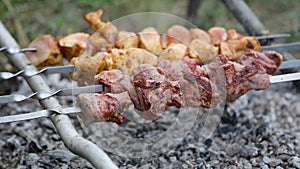 Marinated shashlik or shish kebab preparing on a barbecue grill over charcoal. Skewered meat roasted beef kebabs on BBQ grill.