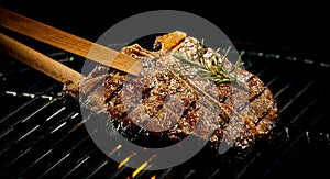 Marinated spicy lean t-bone steak on a BBQ photo