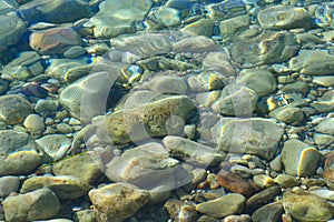 Marine background. Quiet Adriatic Sea. Blue clear water and large stones.