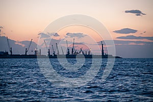 Marine cargo port with cranes at sunset