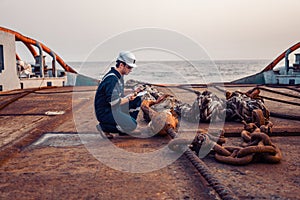 Marine chief officer or chief mate on deck of ship or vessel. He fills up ahts vessel checklist. Ship routine paperwork